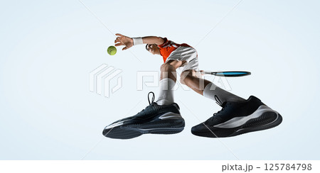 Powerful serve from low angle with tennis player in flight ready to hit against white studio background. 125784798