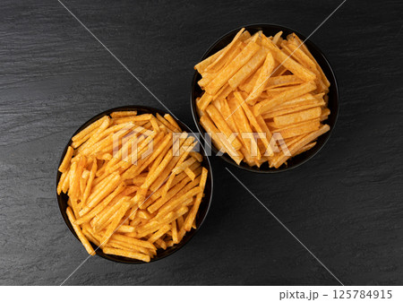 Fried chips sticks, finger potato chips, golden shoestring fries pile, French fries 125784915