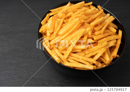 Fried chips sticks, finger potato chips, golden shoestring fries pile, French fries 125784917