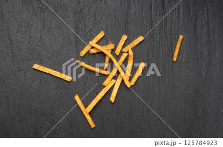 Fried chips sticks, finger potato chips, golden shoestring fries pile, French fries 125784923