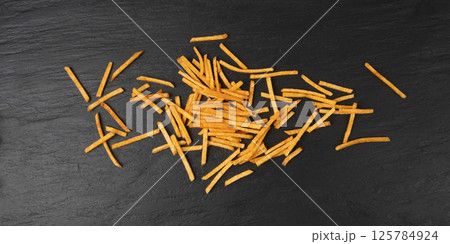 Fried chips sticks, finger potato chips, golden shoestring fries pile, French fries 125784924