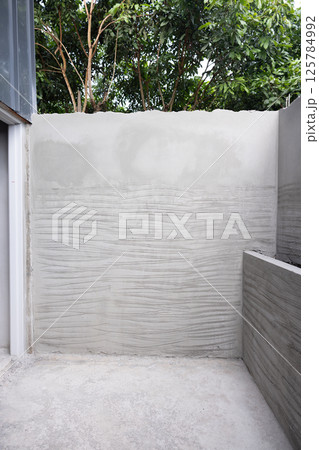 Concrete plastering wall and scrate surface to prepare for tile installation. 125784992