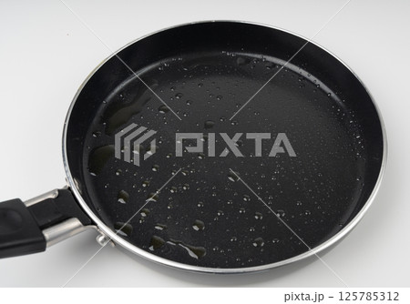 Oil drops on frying pan texture, water splash on black non-stick coating, drop on non stick griddle Oil drops on frying pan texture, water splash on black non-stick coating, drop on non stick griddle 125785312