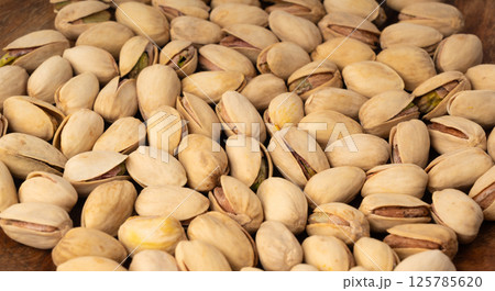 Fried salt pistachio nuts texture background. Baked pistachios pattern, roasted green pistache 125785620