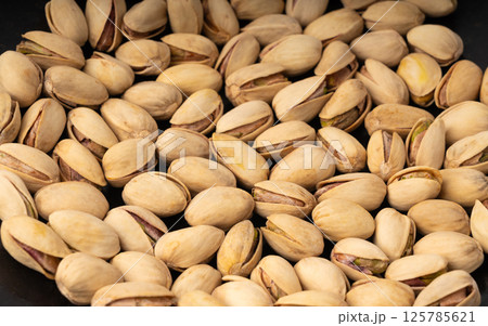 Fried salt pistachio nuts texture background. Baked pistachios pattern, roasted green pistache Fried salt pistachio nuts texture background. Baked pistachios pattern, roasted green pistache 125785621