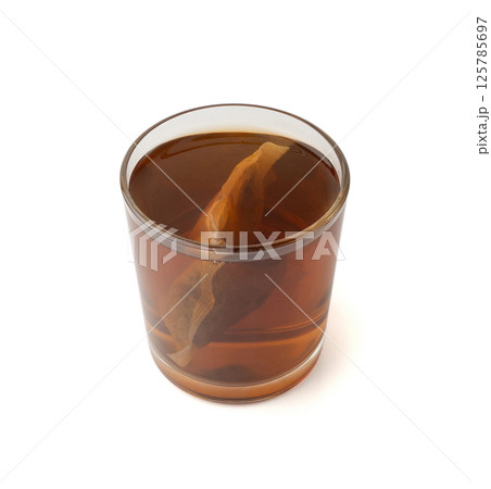 Herbal tea sachet in glass, hot water with chamomile and Hypericum or St. John's wort teabag Herbal tea sachet in glass, hot water with chamomile and Hypericum or St. John's wort teabag 125785697