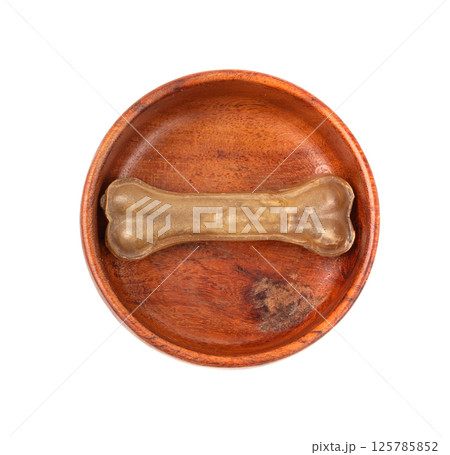 One rawhide bone in bowl isolated, single collagen dog chew food, pressed dry kibble 125785852