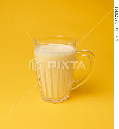 Vanilla milk shake in glass. Milkshake on yellow background, white whey protein smoothie 125785914