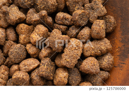 Dry pet food macro pieces, cat kibble closeup, dog pellets, small protein croquettes detailed 125786000