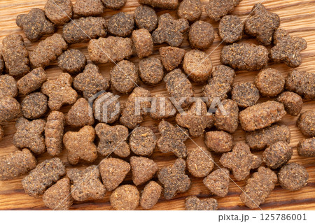 Dry pet food macro pieces, cat kibble closeup, dog pellets, small protein croquettes detailed 125786001