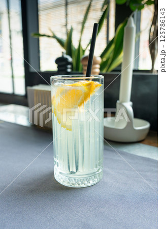 Ice lemonade in tall glass. Yuzu mocktail with lemon and soda, cool lime juice cocktail Ice lemonade in tall glass. Yuzu mocktail with lemon and soda, cool lime juice cocktail 125786143