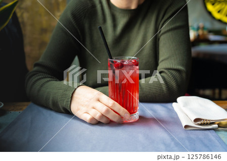 Cold lingonberry drink on restaurant table. Iced cowberry tea, refreshing cranberry cocktail Cold lingonberry drink on restaurant table. Iced cowberry tea, refreshing cranberry cocktail 125786146