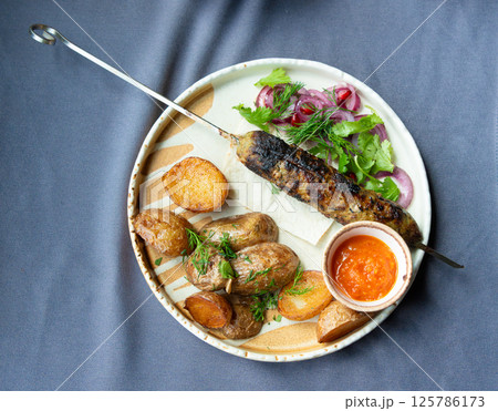 Georgian lula kebab plate. Bbq skewer, traditional barbecue dish with baked potatoes, sauce 125786173