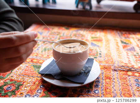 Masala chai an Indian restaurant, spiced milk tea, traditional cardamom hot drink with spices 125786299