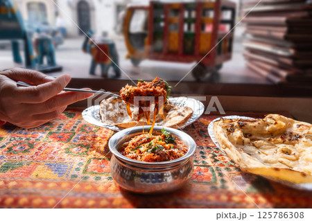 Lamb curry with tomatoes and fiery chili, traditional Indian Laal Maas served in a metal dish 125786308