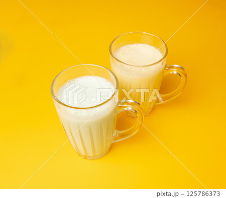 Vanilla milk shake in glass. Milkshake on yellow background, white whey protein smoothie 125786373