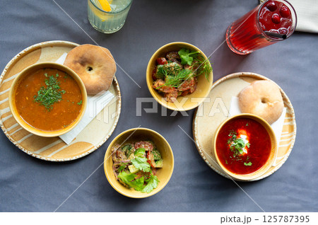 Top view of a traditional lunch with soup, salad, bread, and drinks served on a table Top view of a traditional lunch with soup, salad, bread, and drinks served on a table 125787395