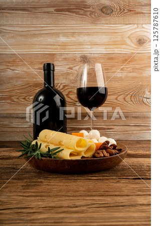 Cheese plate of color cheeses variety, yellow, white and blue gorgonzola platter with red wine glass Cheese plate of color cheeses variety, yellow, white and blue gorgonzola platter with red wine glass 125787610