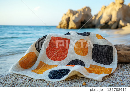Beach towel with bold geometric patterns in summer beach. Retro style. Close-up. Beach towel with bold geometric patterns in summer beach. Retro style. Close-up. 125788415