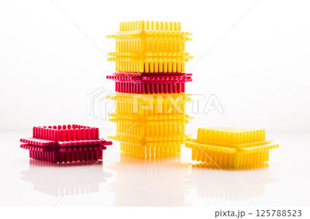 The children's building set consists of bright blocks that are easy to connect. The colorful elements on the white background create a positive mood. 125788523