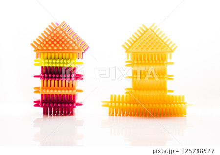 The elements of the children's construction toy harmonize well with the background color. The plastic building blocks of the play set attract with their shape and color. 125788527
