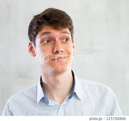 Portrait of young puzzled guy in studio Portrait of young puzzled guy in studio 125788866