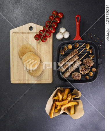 grilled meat and shasliks with mushrooms and tomatos served with french fries grilled meat and shasliks with mushrooms and tomatos served with french fries 125789254