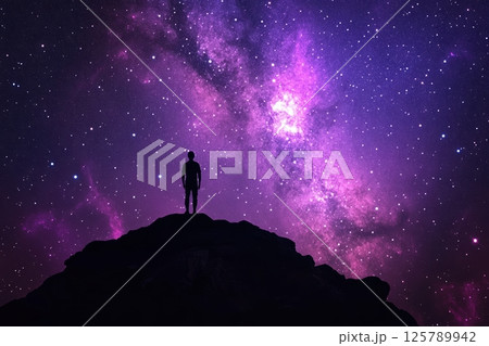 Silhouette of person on mountain under vibrant starry night sky with purple nebula 125789942