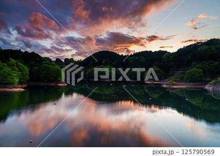 雨上がりの夕空でダイナミックに変化していく風景クライマックスを過ぎ次第に消失していく夕焼け空　湖上① 125790569