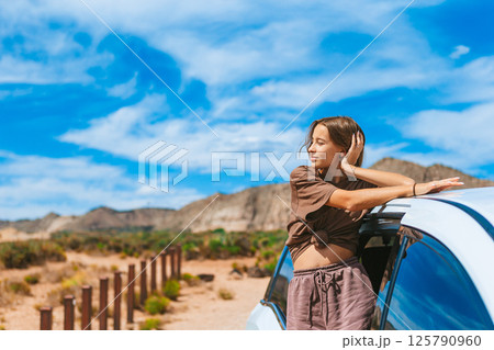 Young girl on trail at Fire Valley in Utah at Nevada State Park traveling by car through the mountains Young girl on trail at Fire Valley in Utah at Nevada State Park traveling by car through the mountains 125790960