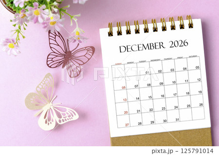 December 2026 desk calendar for the organizer to plan and reminder and paer butterfly on pink background. December 2026 desk calendar for the organizer to plan and reminder and paer butterfly on pink background. 125791014