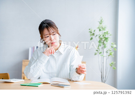 家計簿をつける女性 家計簿をつける女性 125791392