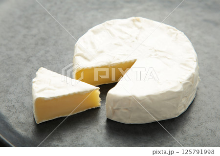 Slice camembert cheese on dark background. 125791998