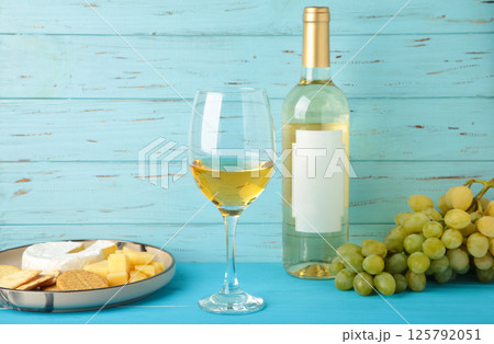Wine tasting. Parmesan cheese with glass of wine and grape on blue background. Cheese plate. Wine card, restaurant menu. Wine tasting. Parmesan cheese with glass of wine and grape on blue background. Cheese plate. Wine card, restaurant menu. 125792051