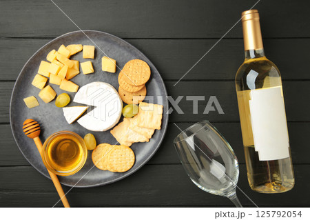 Wine tasting. Parmesan cheese with glass of wine on black wooden background. Cheese plate. Wine card, restaurant menu. Wine tasting. Parmesan cheese with glass of wine on black wooden background. Cheese plate. Wine card, restaurant menu. 125792054