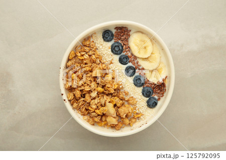 Granola with fresh summer berries in a bowl on light background. Concept of healthy breakfast food Granola with fresh summer berries in a bowl on light background. Concept of healthy breakfast food 125792095