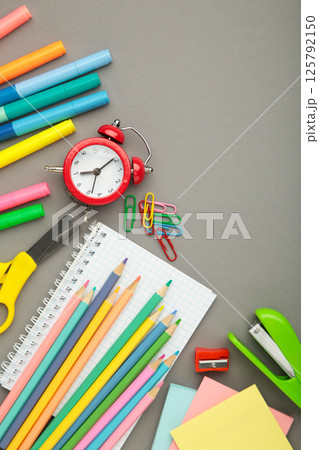 Studio shot of school supplies on grey background. Vertical photo Studio shot of school supplies on grey background. Vertical photo 125792150