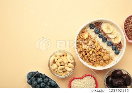 Oat raisin granola with fresh summer berries in a bowl on beige background. Space for text Oat raisin granola with fresh summer berries in a bowl on beige background. Space for text 125792156