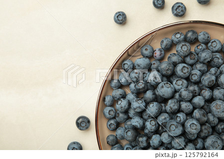 Beige ceramic bowl of fresh ripe blueberries on light background. 125792164