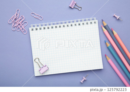 School supplies concept. Open notebook with colorful pencil on purple background School supplies concept. Open notebook with colorful pencil on purple background 125792223