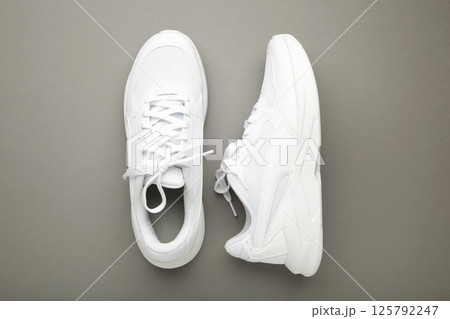 White sneakers on a grey background. Space for text 125792247