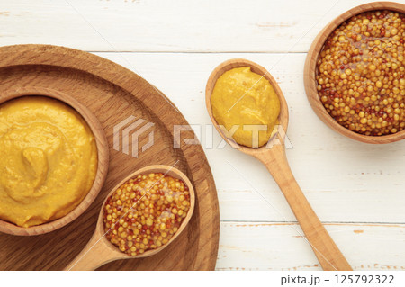 Dijon mustard with french mustard on white wooden background. 125792322