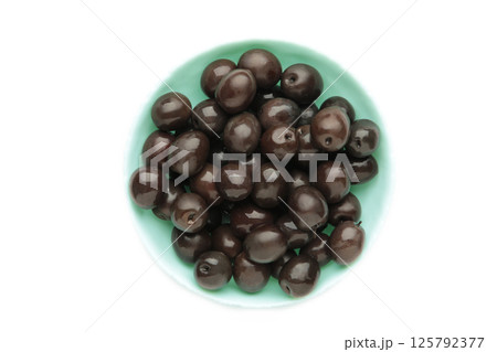 Blue bowl of pickled black olives isolated on white background, top view 125792377