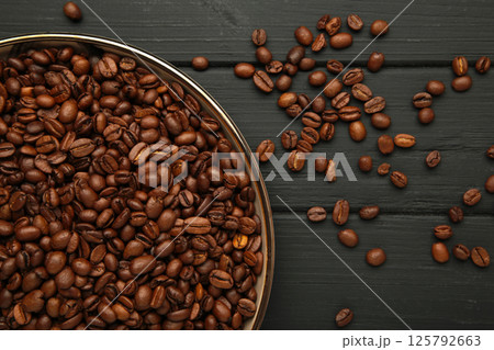 Coffee beans on plate on black background 125792663