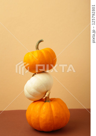 Thanksgiving and Autumn decoration. Mini pumpkins on beige background. Thanksgiving and Autumn decoration. Mini pumpkins on beige background. 125792801