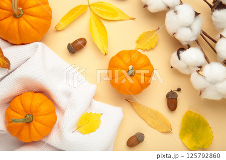 Cozy knitted sweaters with leaves and pumpkins on beige background. Thanksgiving day Cozy knitted sweaters with leaves and pumpkins on beige background. Thanksgiving day 125792860