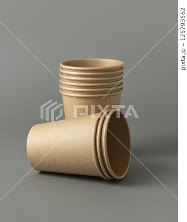 Disposable beige kraft paper cups on a gray closeup, mockup. No plastic and sustainable lifestyle 125793562