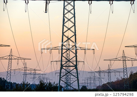 High voltage power lines over a field at sunset 125794298