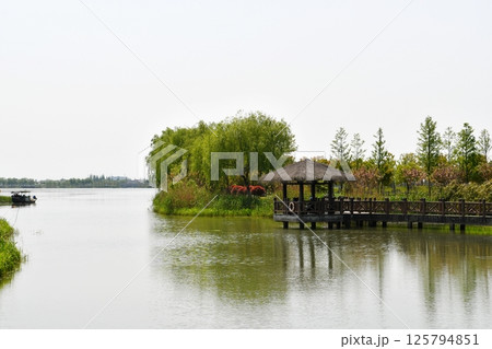 a traditional Chinese wooden pavilion on the water 125794851