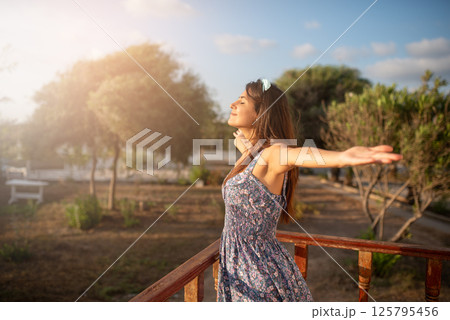 Happy smiling woman raising her hands up. 125795456